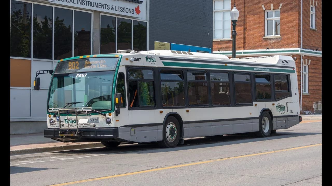 A Durham Region Transit bus (number 8567) on a street in Bowmanville, Ontario; no people visible.