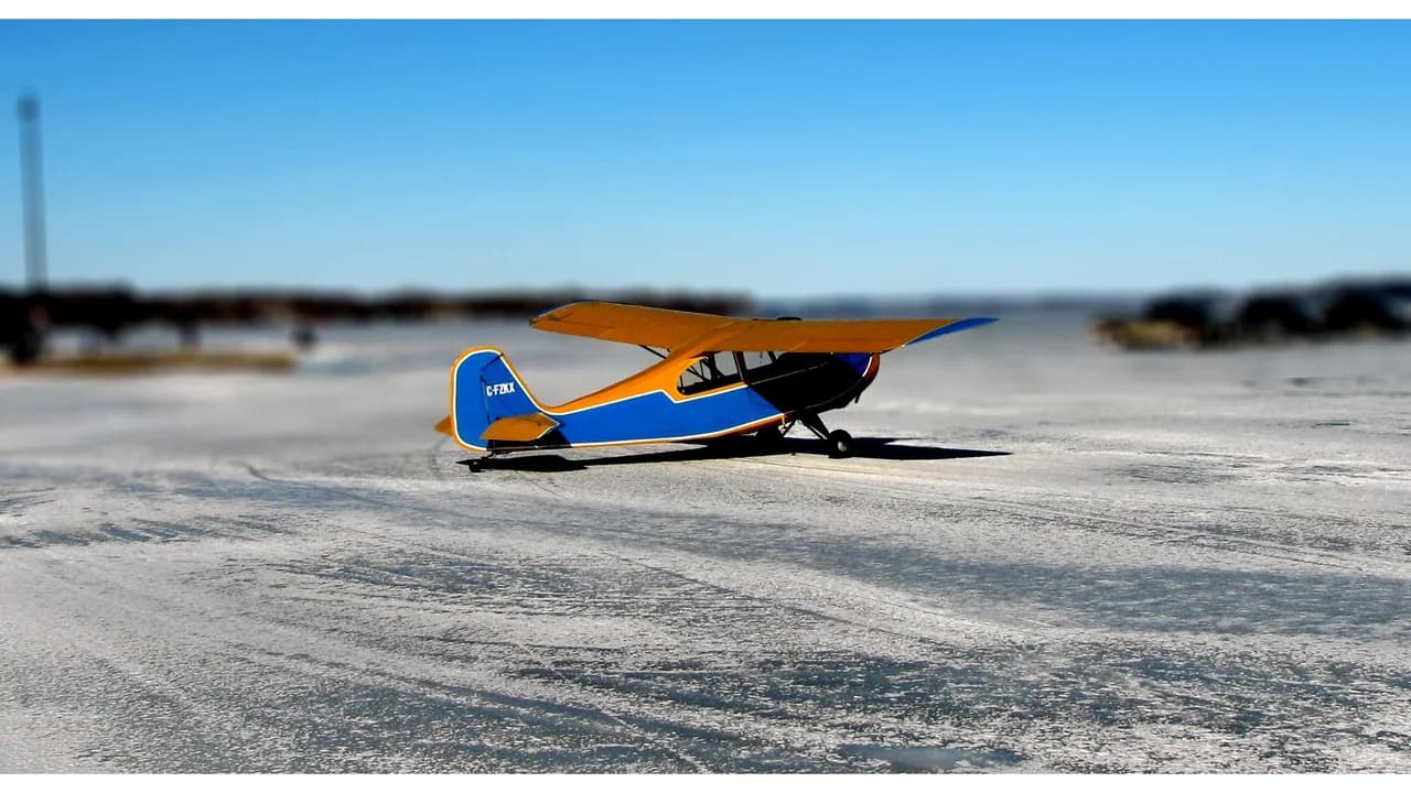 A small plane on the frozen surface of Lake Scugog under a clear blue sky; no people visible.