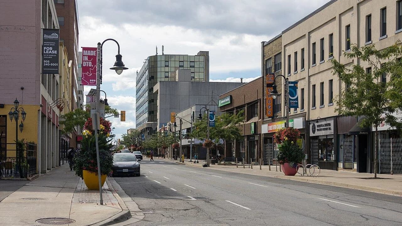 King Street in downtown Oshawa with storefronts and 'Made in DTO' banners, September 2026; no people with visible faces